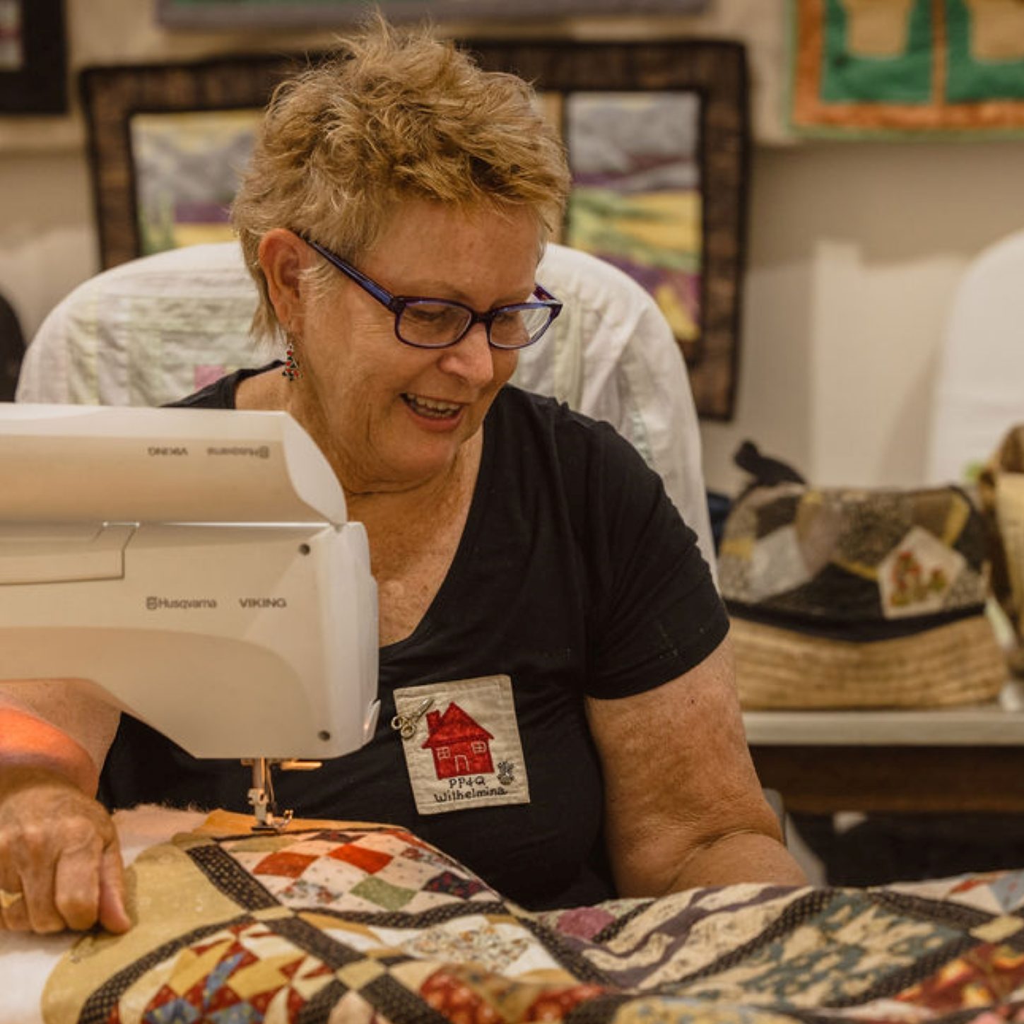 Older woman showing young girl a quit on a sewing machine.